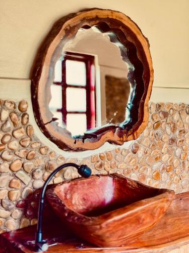 a bathroom sink with a wooden mirror above it at Bwindi Coffee Lodge in Kachulagenyi