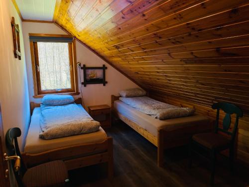 a attic room with two beds and a window at Leilighet toppetasje, Flekkefjord in Flekkefjord