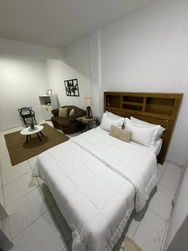 a bedroom with a large white bed and a couch at Habitación centro in Ciudad del Este