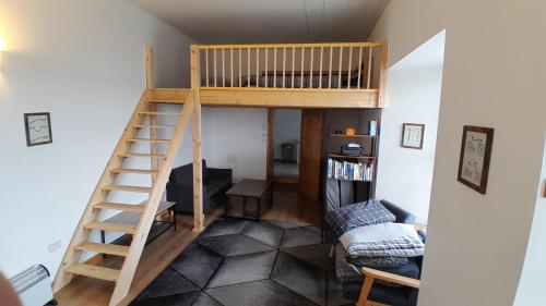 a room with a loft bed and a living room at The Uyeasound Old Pier Cottage in Belmont
