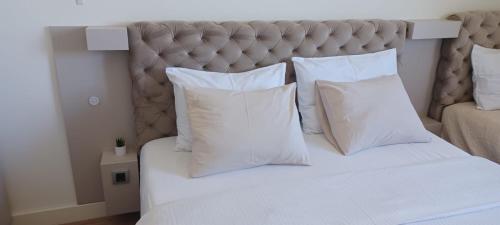 a bedroom with a white bed with white pillows at Belgrade Waterfront Sole in Sajmište