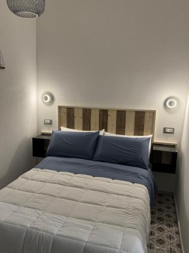 a bedroom with a large bed with blue pillows at MARIMA' la Casa Vacanze - Holidays Suites in Maratea