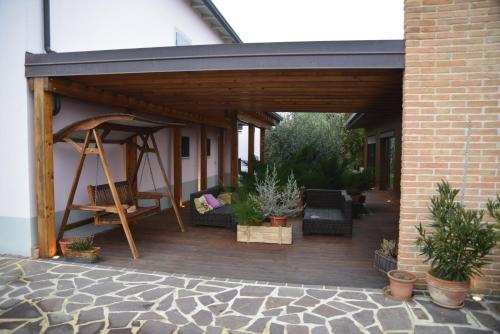 a porch with a wooden deck with a swing at Dolce Casetta in Faenza