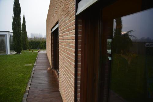 a brick building with a wooden walkway next to a door at Dolce Casetta in Faenza