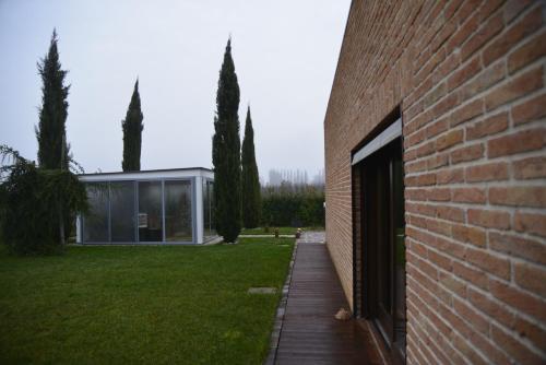a brick building with a door next to a yard at Dolce Casetta in Faenza