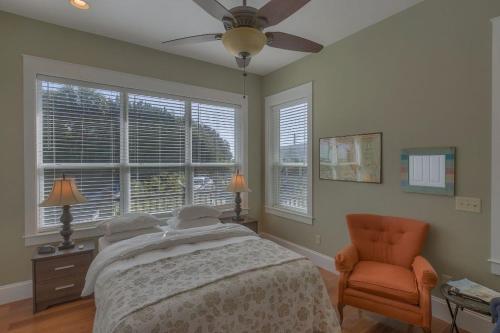 a bedroom with a bed and a chair and windows at Camp Palms @ Indian Pass by Pristine Properties Vacation Rentals in Indian Pass