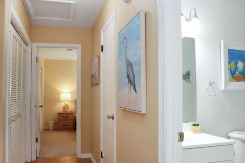 a bathroom with a painting of a bird on the wall at Woofs and Waves by Pristine Properties Vacation Rentals in Cape San Blas
