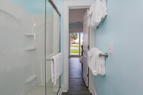 a bathroom with towels hanging on a glass door at Beach View Lower by Pristine Properties Vacation Rentals in Mexico Beach
