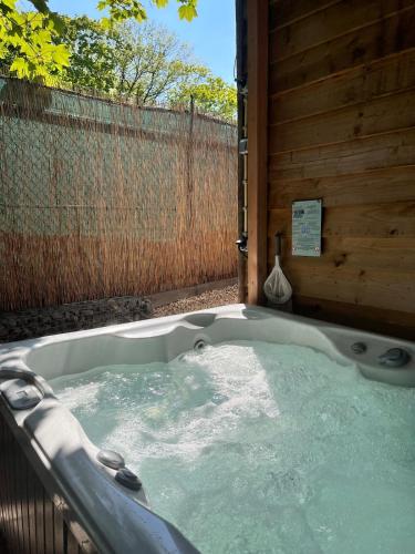 a jacuzzi tub in a backyard with a fence at B&B Spoor 1 met jacuzzi in Nieuwe Vaart