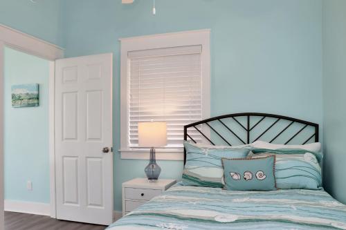 a bedroom with a bed with blue walls at Beach View Upper by Pristine Properties Vacation Rentals in Mexico Beach
