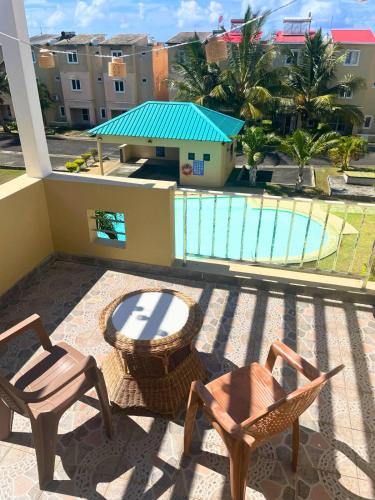 a balcony with two chairs and a table and a pool at Triplex - Suite parentale in Grande Gaube