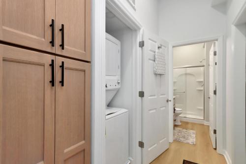 a bathroom with white cabinets and a washer and dryer at Dolphin Daze Hideaway by Pristine Properties Vacation Rentals in Saint Joe Beach