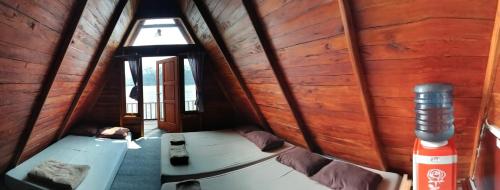 a room with wooden walls and a room with a mattress at Banyu 2 in Palayangan