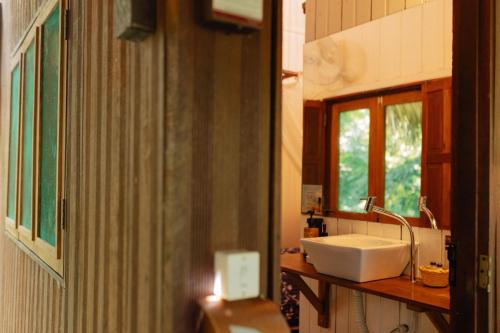 a bathroom with a white sink and a window at Villa Arumã Pousada in Alter do Chao