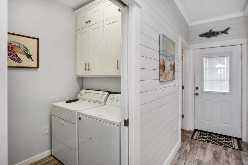 a white laundry room with a washer and dryer at Set Sail at 5 by Pristine Properties Vacation Rentals in Mexico Beach