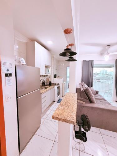 a kitchen with a couch in the middle of a room at Apartamento Mirim Praia Grande in Praia Grande