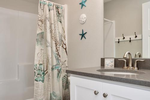 a bathroom with a sink and a shower curtain at Pelican Roost A by Pristine Properties Vacation Rentals in Mexico Beach