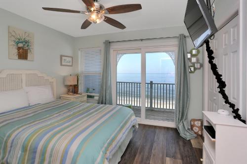 a bedroom with a bed and a balcony with the ocean at Sandcastle C by Pristine Properties Vacation Rentals in Mexico Beach