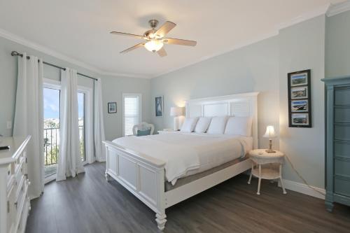 a white bedroom with a bed and a ceiling fan at Paradise Shores 302 Serenity Shores by Pristine Properties Vacation Rentals in Mexico Beach