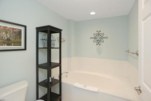 a bathroom with a white tub and a black shelf at Paradise Shores 302 Serenity Shores by Pristine Properties Vacation Rentals in Mexico Beach