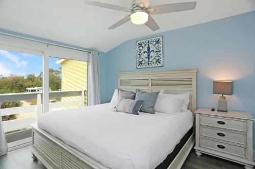 a bedroom with a bed with a ceiling fan and a window at Sharla's Sunrise by Pristine Properties Vacation Rentals in Indian Pass