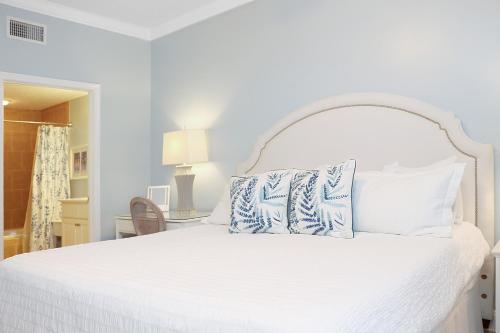 a bedroom with a white bed with blue pillows at Summerhouse 309 by Pristine Properties in Mexico Beach