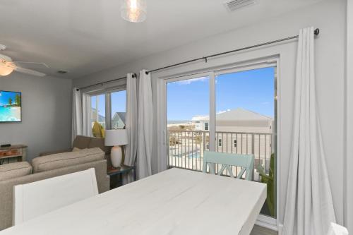 a living room with a white table and a large window at Surfside 15 - Beachtime by Pristine Properties Vacation Rentals in Mexico Beach