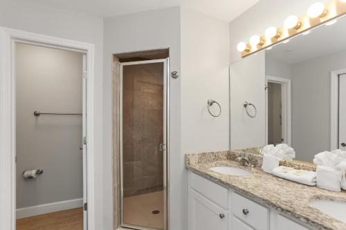 a white bathroom with two sinks and a shower at Surfside 15 - Beachtime by Pristine Properties Vacation Rentals in Mexico Beach