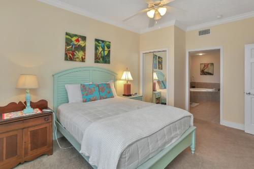 a bedroom with a bed with a blue headboard and a table at Summerhouse 203 by Pristine Properties Vacation Rentals in Mexico Beach