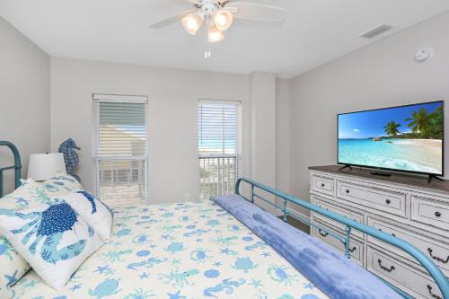 a bedroom with a bed and a flat screen tv at Surfside 17 by Pristine Properties Vacation Rentals in Mexico Beach