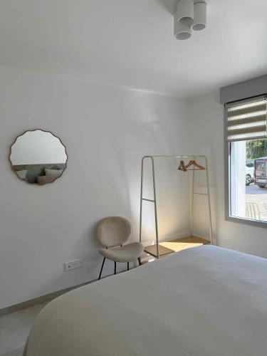a bedroom with a bed and a chair and a window at La Bergerie 3 in Neufchâteau