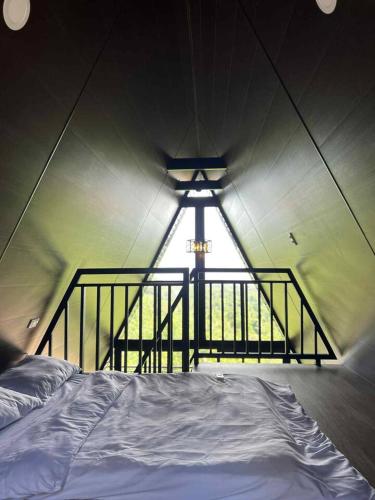 a bed in a room with a large window at Romantic A-Frame Cabin w/ a View + WiFi in Samal