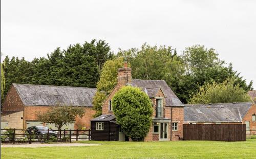an old brick house with a black garage at Hill Farm in Oxford