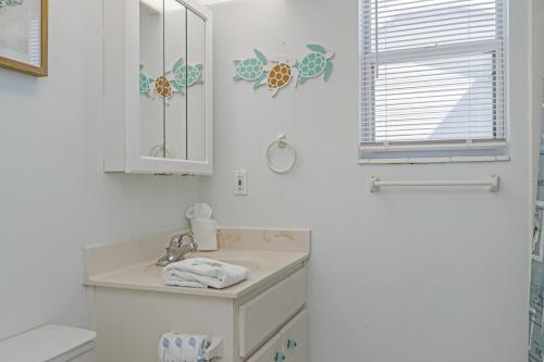 a white bathroom with a sink and a mirror at Whataday by Pristine Properties Vacation Rentals in Cape San Blas