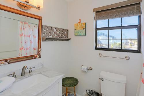 a white bathroom with a sink and a window at Pelican Bend by Pristine Properties Vacation Rentals in Indian Pass
