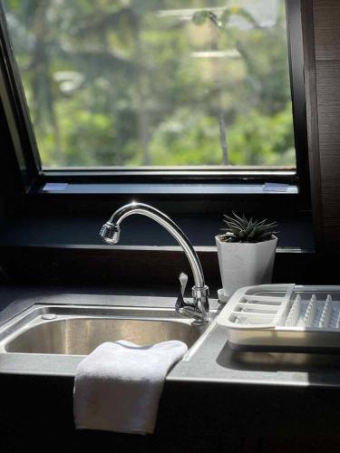 a kitchen sink with a towel and a window at Romantic A-Frame Cabin w/ a View + WiFi in Samal