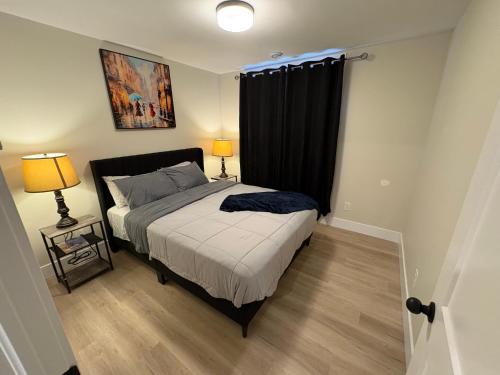 a bedroom with a bed with a black curtain at Modern Private Suite in Moncton