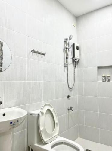 a bathroom with a shower and a toilet and a sink at Balay by JMB in Legazpi