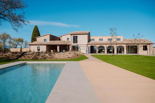 a large house with a swimming pool in front of it at Hotel Mas Vidal Vilafreser in Vilademuls