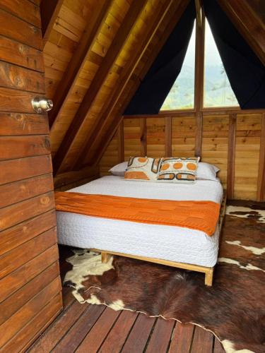 a bed in a room in a cabin at Refugio Nidos del Condor Cocora in Salento
