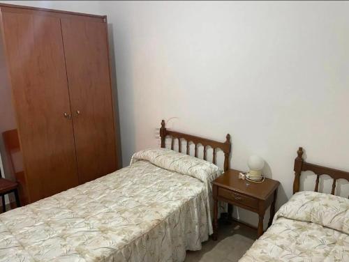 a bedroom with two beds and a table and a cabinet at Casa Villa Zarcillo in Torreorgaz