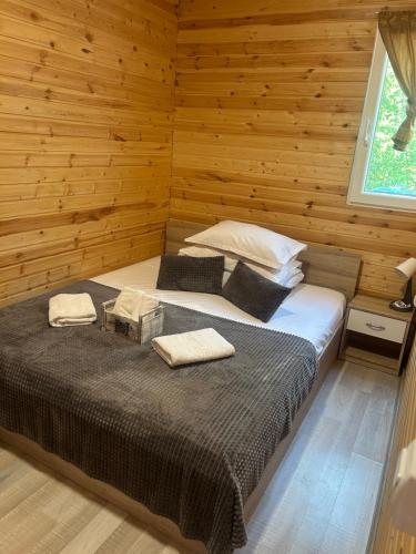 a bedroom with a bed in a wooden room at COMPLEX TURISTIC Gradina de corzi si Aventura Eselnita in Eşelniţa