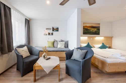 a hotel room with a bed and two chairs at Hotel Gisela in Kufstein