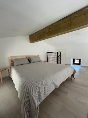a bedroom with a large bed in a white room at Apartma OLJKA in Črniče