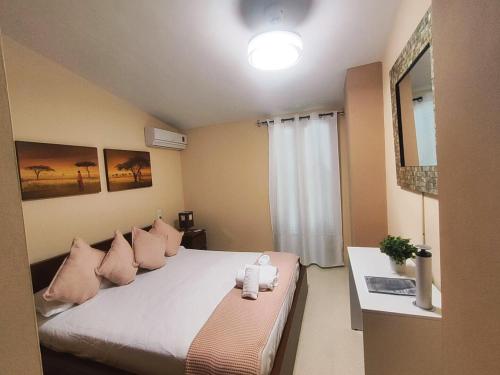 a bedroom with a large bed with pink pillows at Adosado kintsuji in Sanlúcar de Barrameda