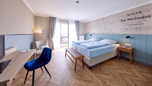 a bedroom with a bed and a desk and a chair at Aparthotel Kachelot in Borkum