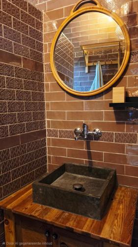 a bathroom with a stone sink with a mirror at La Estación del Amor - Casa Rural con private pool in Alora