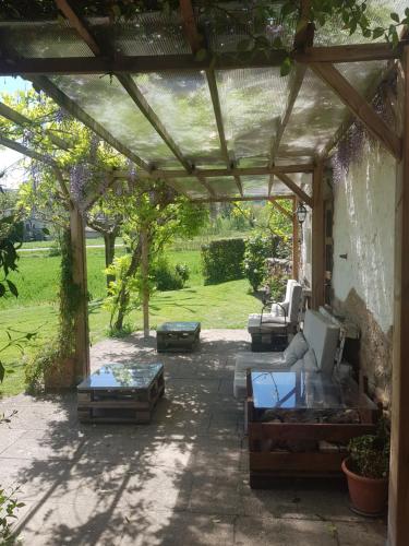 eine Pergola mit Sofas und Tischen auf einer Terrasse in der Unterkunft Mas Rubió in Joanetes
