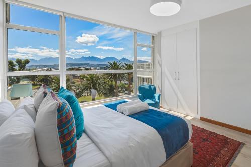 a bedroom with a bed and a large window at Coastal Condo Strand in Strand