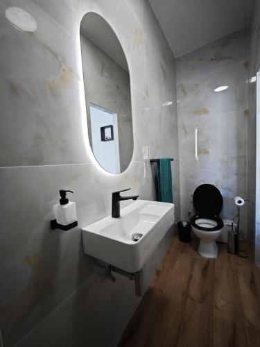 a bathroom with a sink and a toilet and a mirror at 119 Bliss Apartment in Sliema